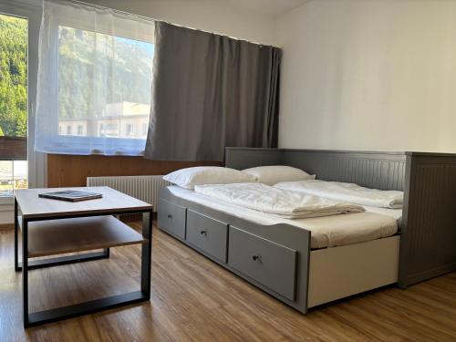 a bedroom with a bed with a table and a window at Chesa in Selva in St. Moritz