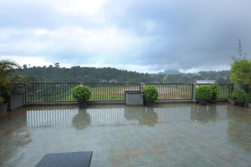 a balcony with potted plants and a fence at Hotel Mayo in Wayanad