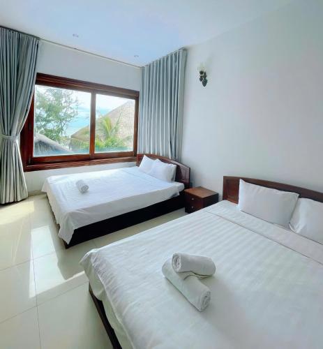 a hotel room with two beds and a window at Resort HAVANA in Mui Ne