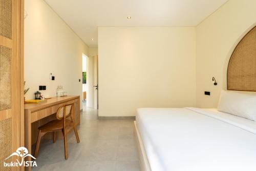 a bedroom with a bed and a desk at Kahuna Villas by Bukit Vista in Sanur