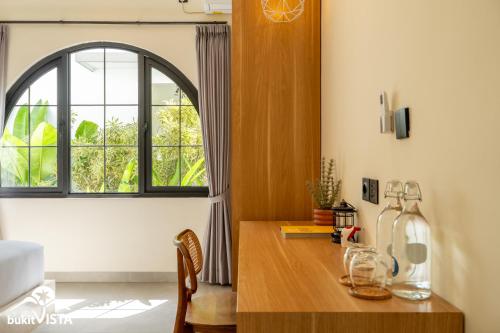 a kitchen with a wooden table and a window at Kahuna Villas by Bukit Vista in Sanur