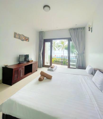 a bedroom with two large beds and a television at Resort HAVANA in Mui Ne