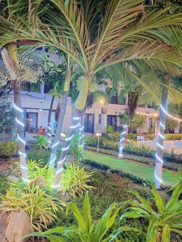 a resort with palm trees in front of a building at Resort HAVANA in Mui Ne