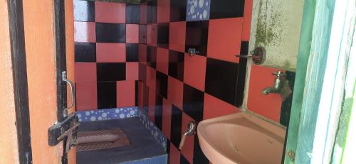 a tiled bathroom with a toilet and a mirror at Mountain Valley Home Stay in Darjeeling