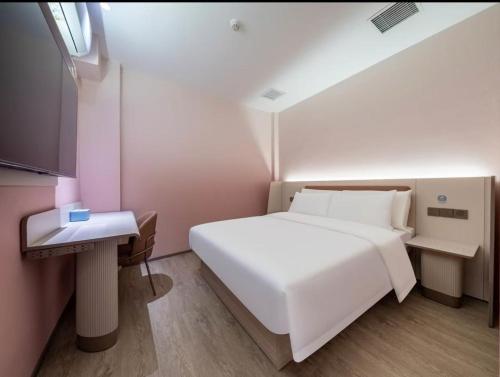 a small bedroom with a white bed and a window at Hanting Hotel Beijing Tiananmen Square in Beijing