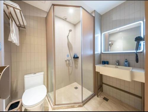 a bathroom with a shower with a toilet and a sink at Hanting Hotel Beijing Tiananmen Square in Beijing