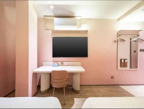 a room with a desk and a tv on a wall at Hanting Hotel Beijing Tiananmen Square in Beijing