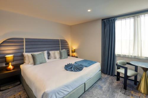 a bedroom with a bed and a table and a desk at Marsden Suites Albany in Albany