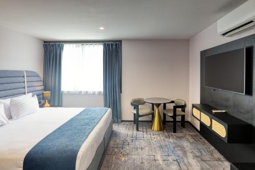 a hotel room with a bed and a flat screen tv at Marsden Suites Albany in Albany