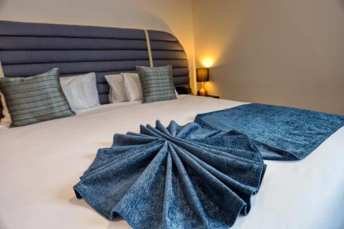 a large bed with a blue dress on it at Marsden Suites Albany in Albany