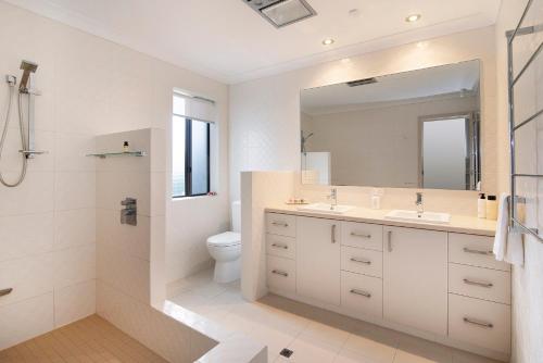 une salle de bain avec un lavabo, des toilettes et un miroir dans l'établissement Gifford Getaway - Coastal Home in Dunsborough, à Dunsborough