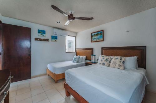 a bedroom with two beds and a ceiling fan at Departamento KAY a orilla del Mar, Progreso in Progreso