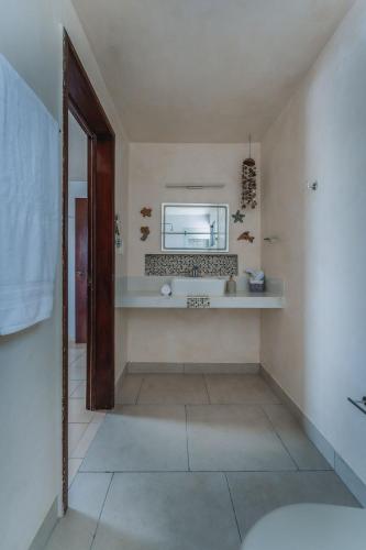 a bathroom with a sink and a mirror on the wall at Departamento KAY a orilla del Mar, Progreso in Progreso