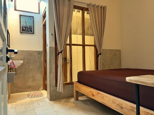 a bedroom with a bed and a sliding glass door at KOTTA Hostel in Timuran