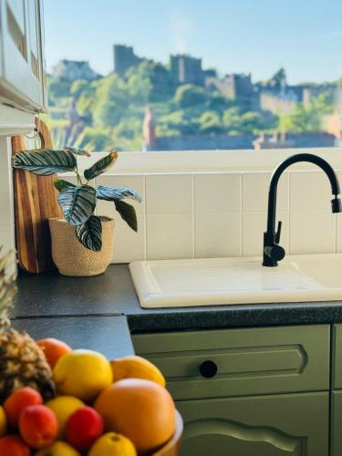 a kitchen counter with a sink and a bowl of fruit at The View on Castle Hill with Lovely Hot Tub in Conwy