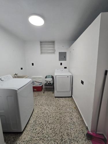 a laundry room with a sink and a washing machine at Casa Los Tercoz in Luquillo