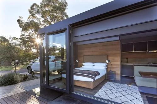 a bedroom with a balcony with a bed on a patio at NRMA Ocean Beach Holiday Resort in Umina