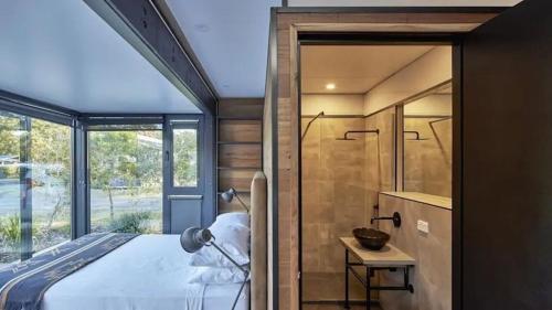 a bedroom with a bed and a shower in a room at NRMA Ocean Beach Holiday Resort in Umina