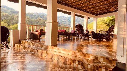 a porch with chairs and a view of the mountains at Dreamcatcher By Brifton Hotel And Resorts in Palolem