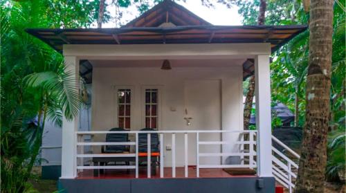a small house with a porch and a white railing at Dreamcatcher By Brifton Hotel And Resorts in Palolem