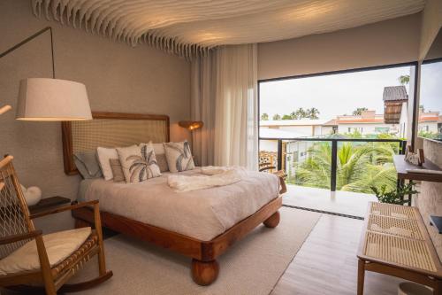 a bedroom with a bed and a balcony at Casa Pura Vida in Maragogi