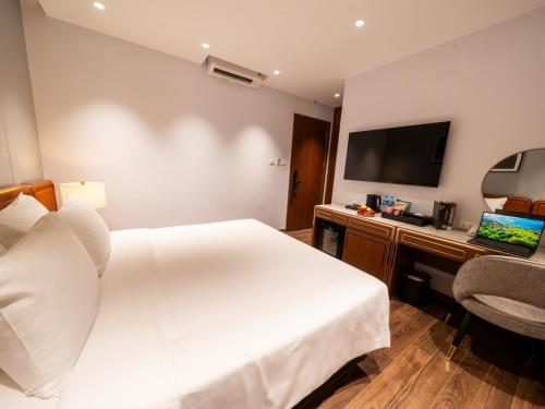 a hotel room with a bed and a desk and a television at San Hanoi Hotel & Gaming in Hanoi