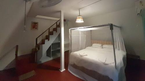 a bedroom with a canopy bed and a staircase at Dreamcatcher By Brifton Hotel And Resorts in Palolem