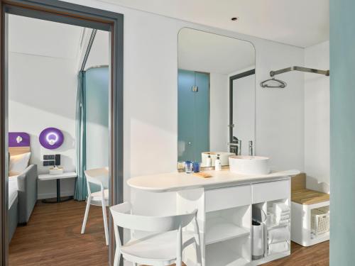 a bathroom with a sink and a mirror at Tru by Hilton Da Nang City Centre in Da Nang