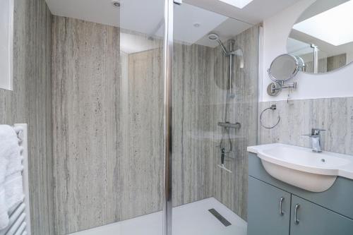 ein Badezimmer mit Dusche und Waschbecken in der Unterkunft Armada Cottage in Dartmouth