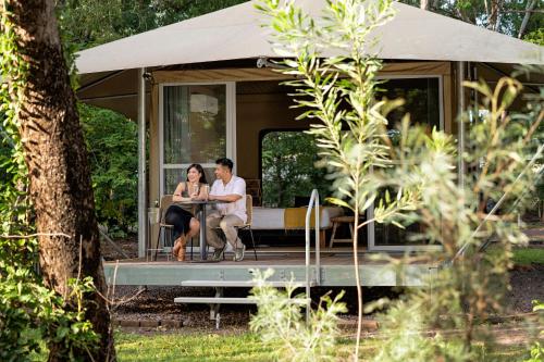 a man and woman sitting in a tiny caravan at Cooinda Lodge Kakadu in Jabiru