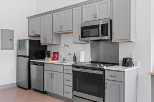 a kitchen with white cabinets and stainless steel appliances at Bright and Modern Studio in Louisville # 303 in Louisville