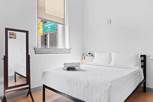a white bed in a room with a mirror at Bright and Modern Studio in Louisville # 303 in Louisville