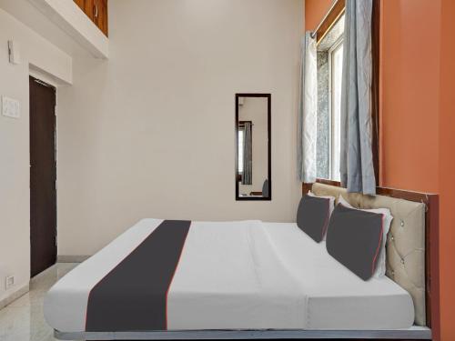 a large bed in a room with orange and white at Hotel O Panchratna in Chakan