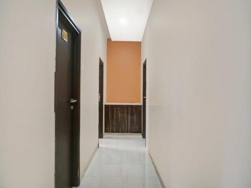 a hallway with an open door and a mirror at Hotel O Panchratna in Chakan