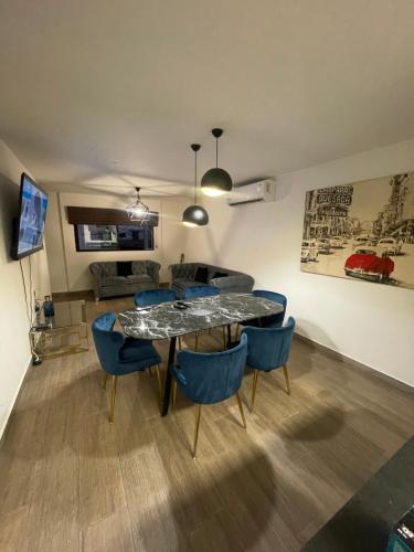 a living room with a table and blue chairs at Departamentos Isla del Carmen in Culiacán