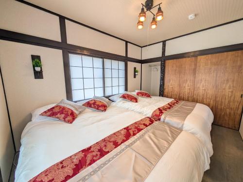 two large beds in a room with two windows at Nagoya Station is 17 minutes by car parking for 2 cars! Up to 11 people pets welcome! in Kiyosu