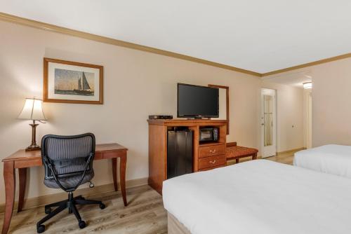 a hotel room with a bed and a desk with a computer at Best Western PLUS Morristown Inn-Florham Park in Morristown