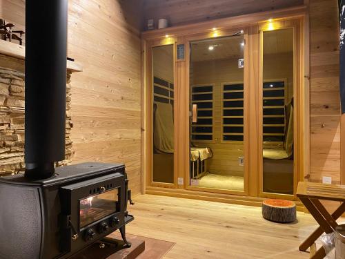 a room with a woodburning stove in front of a window at 蔵Mping Hotel in Fukaya