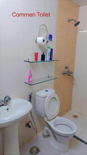 a bathroom with a toilet and a sink at AirNova 3BHK in Sonīpat