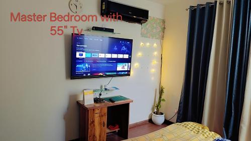 a bedroom with a flat screen tv on the wall at AirNova 3BHK in Sonīpat