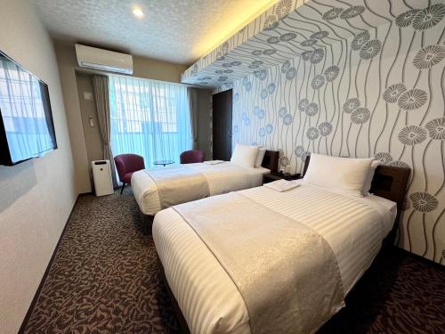 a hotel room with two beds and a wall mural at HOTEL ARROWS Arashiyama in Kyoto