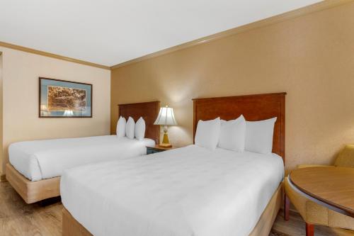 a hotel room with two beds and a table at Best Western PLUS Morristown Inn-Florham Park in Morristown
