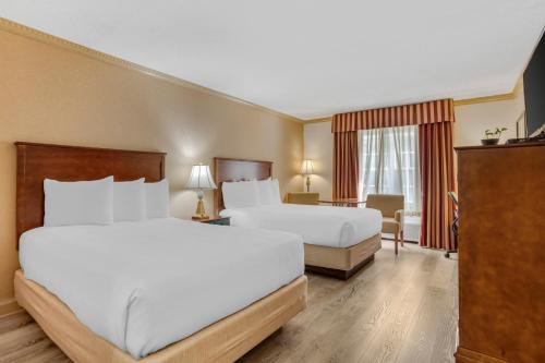 a hotel room with two beds and a television at Best Western PLUS Morristown Inn-Florham Park in Morristown