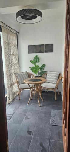 a room with two chairs and a table and a plant at Diamond Stays in Aguada