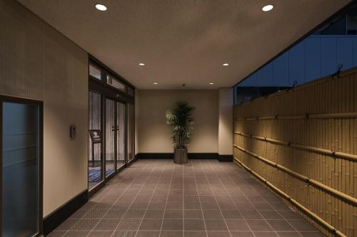 a hallway with a potted plant in a building at HOTEL ARROWS Arashiyama in Kyoto