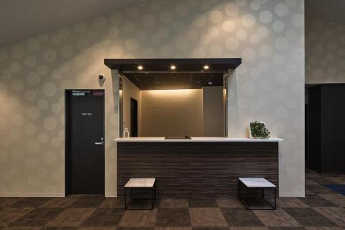 a bathroom with a mirror and a counter with two benches at HOTEL ARROWS Arashiyama in Kyoto