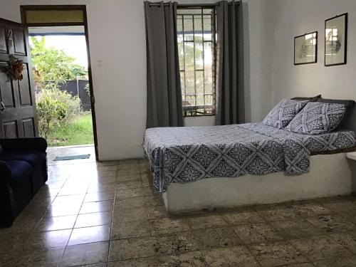 1 dormitorio con 1 cama y puerta a un patio en Roomsmagicoco, en Cahuita