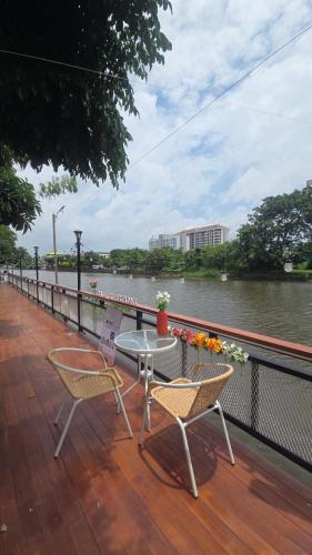 a patio with two chairs and a table next to a river at Grace Riverfront in Lat Krabang