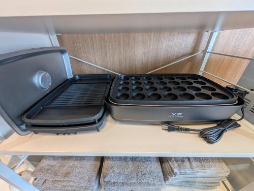 a black appliance sitting on top of a shelf at Nagoya Station is 17 minutes by car parking for 2 cars! Up to 11 people pets welcome! in Kiyosu