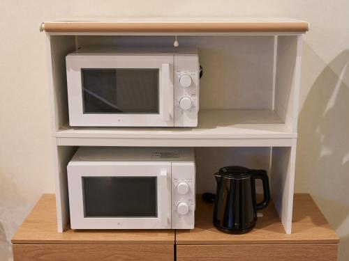 a microwave and a toaster oven on a shelf at Retrospect Stay Yokohama in Yokohama